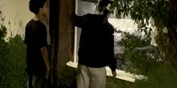 VIDEO: 3 jonge gasten met capuchon proberen jonge vrouw uit huis te praten